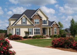 Two story tan and brick home with a new roof.